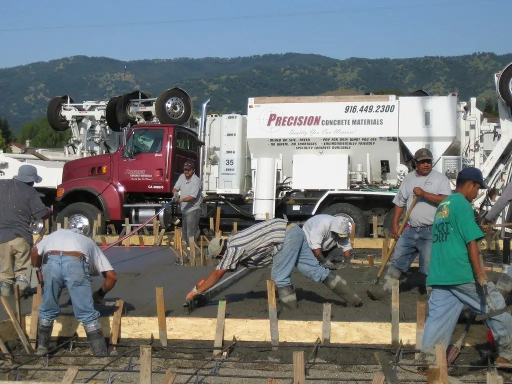 Precision crew placing fresh concrete for a foundation.